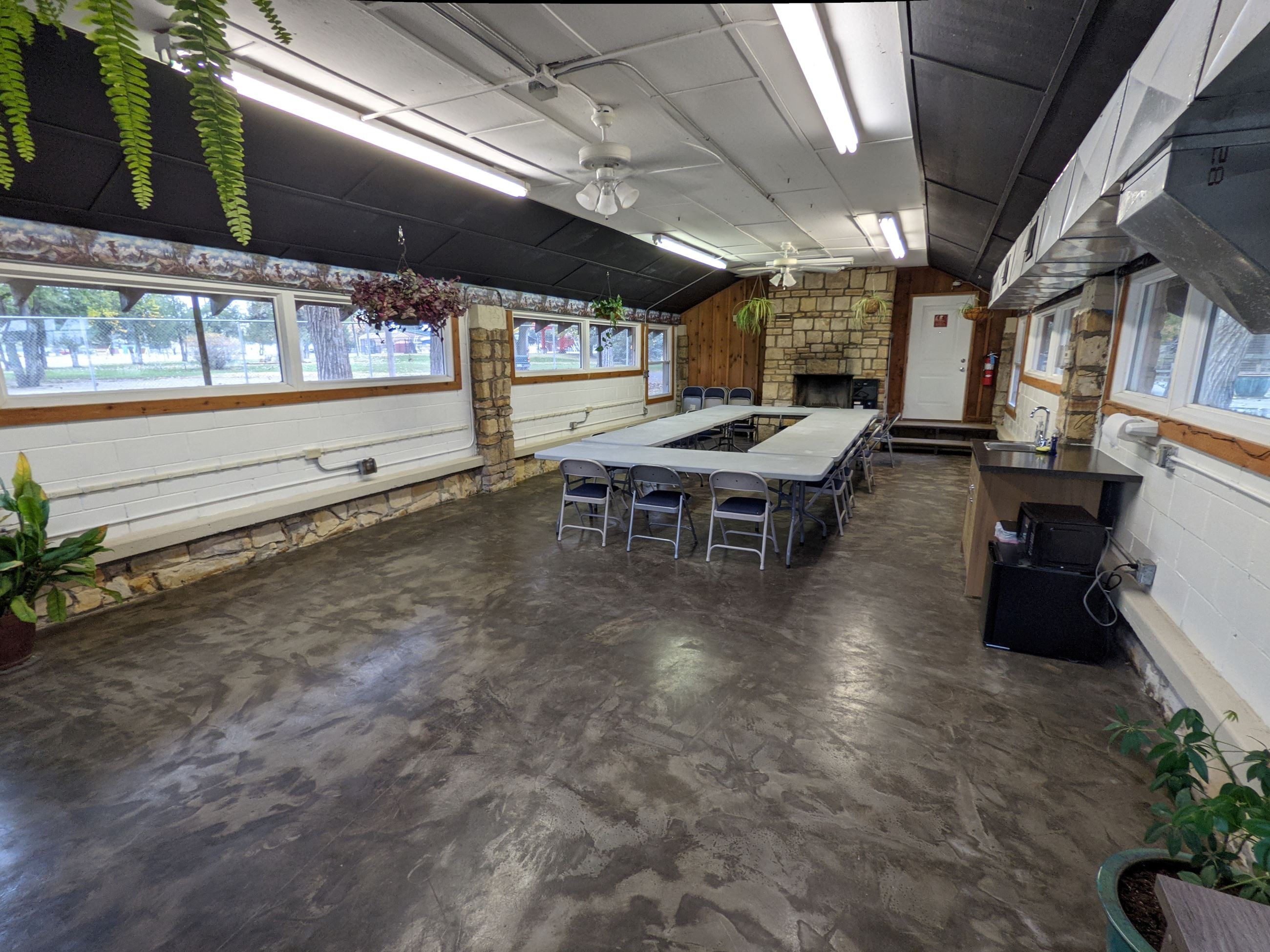 A spacious room featuring a large table surrounded by several chairs